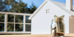 Mortgage points cost calculation: Coins, cash, and a house model.