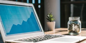 A laptop showing a free DSCR loan calculator and financial graph next to a jar of coins.
