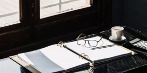 Calculator and pen on a binder, ready to negotiate closing costs with a lender.