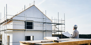 Contractor reviewing blueprints for a home renovation project financed with a construction loan.