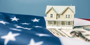 Model house, key, and money on a US flag for VA home loan benefits and eligibility.